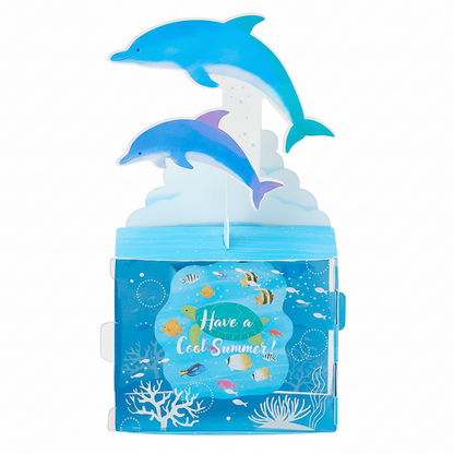 A 3D pop-up cardboard decoration featuring two blue dolphins jumping above an underwater scene box with the text 'Have a Cool Summer!'.